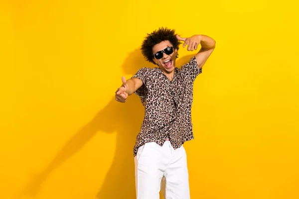 stock image Photo of positive confident guy with afro hair dressed print shirt in sunglass indicating at you isolated on yellow color background.