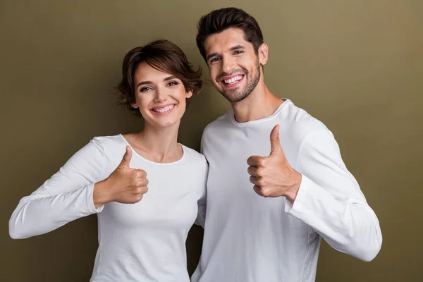 Photo of satisfied cute people wear stylish white clothes hand thumb up positive feedback good job isolated on brown color background.