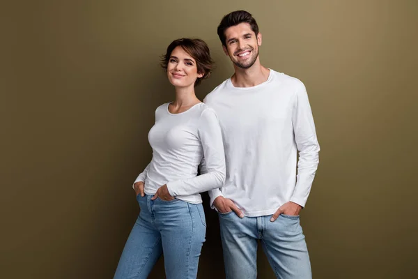 Photo of cute sweet couple dressed trendy white outfit hands pockets good mood isolated on brown color background.