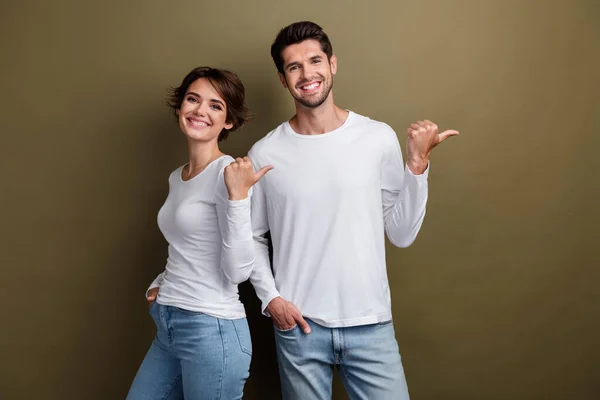 Photo of satisfied cheerful people wear stylish white clothes arm direct special cool offer empty space isolated on brown color background.
