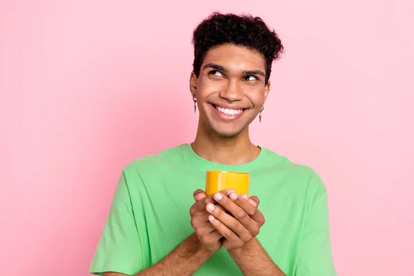 stock image Photo of cheerful nice man wear green clothes old mug tasty tea look up adv empty space isolated on pink color background.