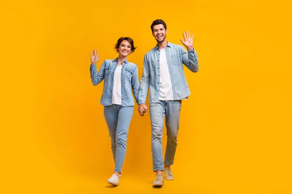 Stock image Full length photo of cheerful optimistic friends dressed jeans stylish clothes walk meet you say hello isolated on yellow color background.