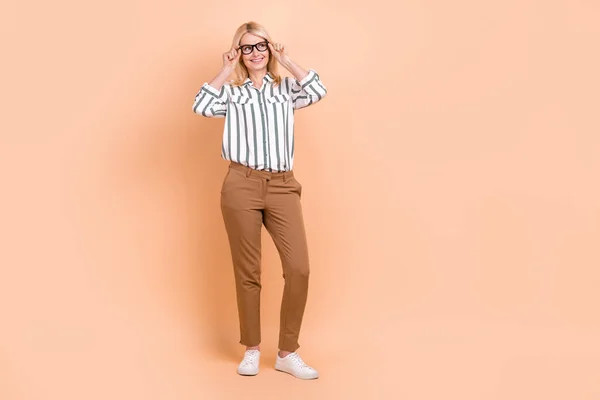 Full body portrait of minded positive lawyer lady arms touch eyewear look empty space isolated on beige color background.