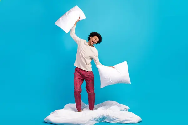 素敵なケアフリーのフルサイズの写真 若い男スタンド白い毛布の手は青い色の背景で隔離された枕を保持します — ストック写真