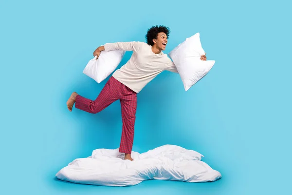 stock image Full size profile photo of overjoyed positive person hold pillows blanket run empty space isolated on blue color background.