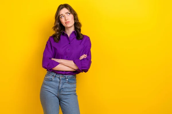 Portrait of minded pensive person folded arms look empty space ponder isolated on yellow color background.