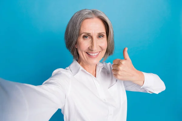 ポジティブな陽気な女性の写真は ビデオを記録する親指を示す白いシャツを着用 ブルーカラーの背景 — ストック写真