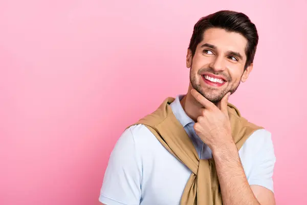 stock image Portrait of satisfied creative young man arm touch chin beaming smile look interested empty space isolated on pink color background.