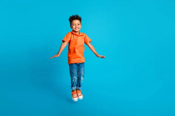 良い気分ファンキーなポジティブな少年小さなジャンプトランポリン空気アクティブなフリータイムをブルーカラーの背景に隔離 — ストック写真