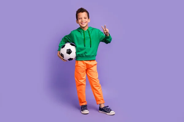 陽気な男の子の全長の写真はスタイリッシュな衣装ハンドを着用し 紫色の背景で隔離されたBサインウィンチャンピオンシップを実証します — ストック写真
