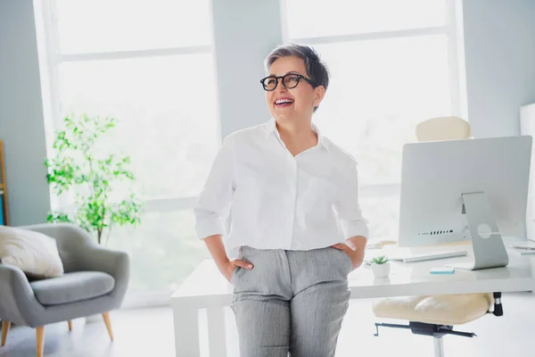照片中 有自信的梦幻女专家身穿白衬衫 满脑子微笑 在室内工作站工作 — 图库照片