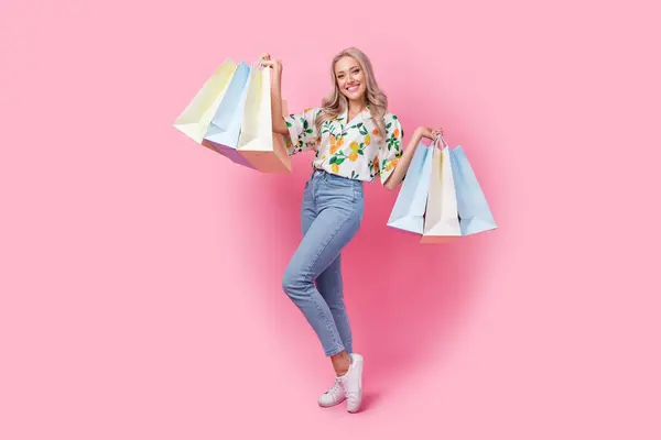 Full length photo of demonstrating her purchases young lady shopaholic zara seasonal sale advertisement isolated on pink color background.