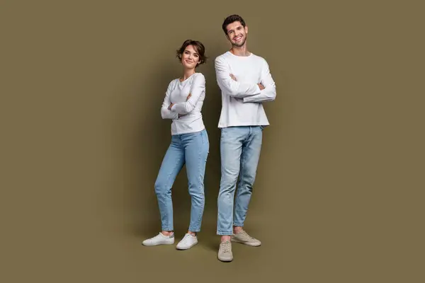Full length photo of cute confident married couple wear white shirts smiling arms crossed isolated brown color background.