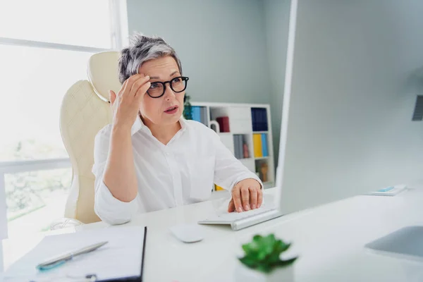 Photo of upset overworked lady accountant wear white shirt feeling bad communicating modern gadget indoors workplace workstation.