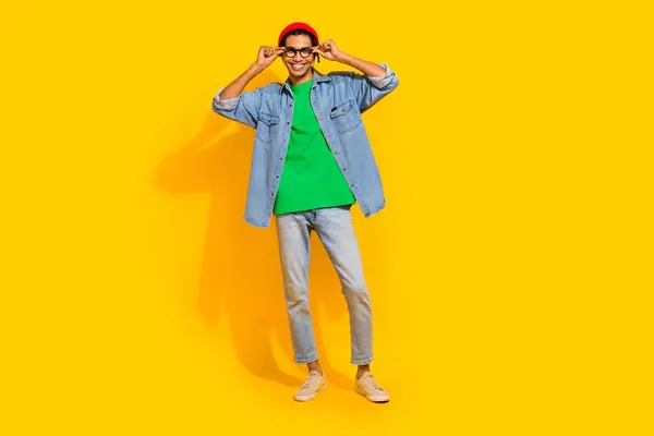 ショッピングバナーポスターをポーズする素敵な若い男のフルサイズの写真は 黄色の背景に隔離されたトレンディなジーンズの服を着ます — ストック写真
