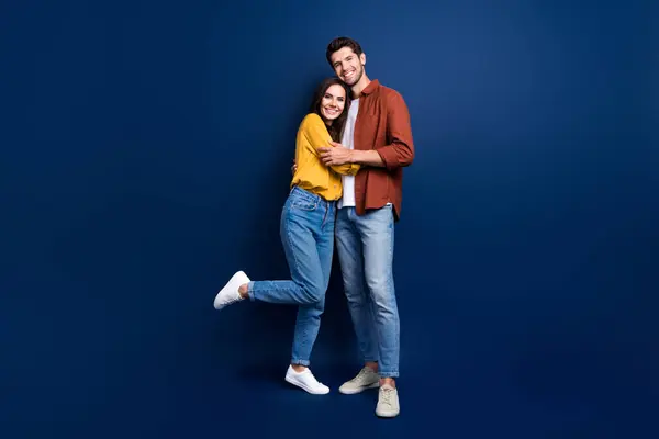 Full body portrait of two peaceful positive people good mood cuddle isolated on dark blue color background.