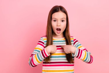 Photo of little funny schoolgirl directing fingers herself blaming shocked everybody call her stupid isolated on pink color background. clipart