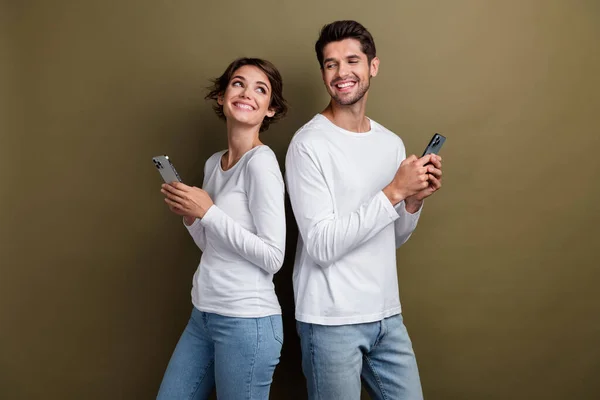 夢のような甘い夫婦の写真は 現代のガジェットを伝える白いシャツを着て 茶色の背景を隔離しました — ストック写真