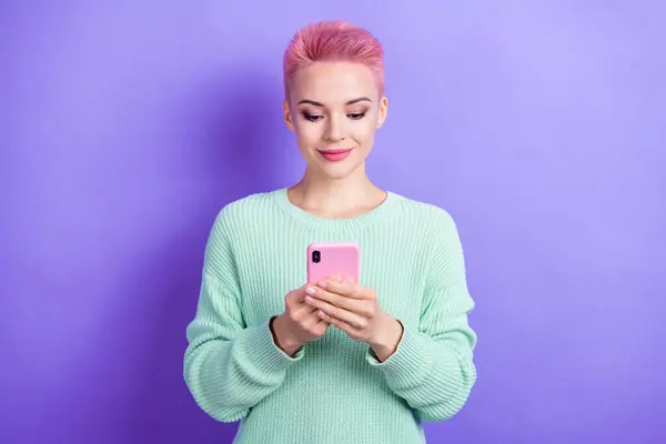 美しい素敵な女の子の肖像画は 紫色の背景で隔離されたスマートフォンタイピングの投稿コメントを書く — ストック写真