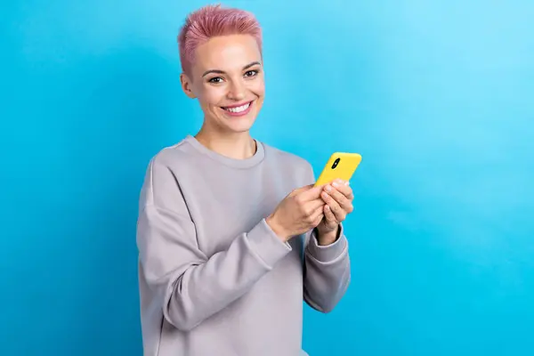 美しい陽気な女性の顔の肖像画は青い色の背景で隔離されたスマートな電話のチャットを使用します — ストック写真