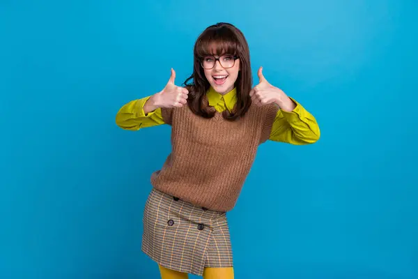 Photo of excited funky lady wear brown vest spectacles showing two thumbs up isolated blue color background.