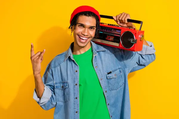 Photo of cheerful nice stylish man trendy outfit hat hold radio listen heavy metal harsh rock roll isolated on yellow color background.