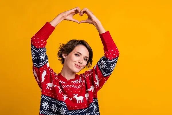 イエローカラーの背景に隔離されたクリスマスイブ上の頭の上に赤いスウェットシャツショーハートを着たボブヘアスタイルの素敵な女の子の写真 — ストック写真