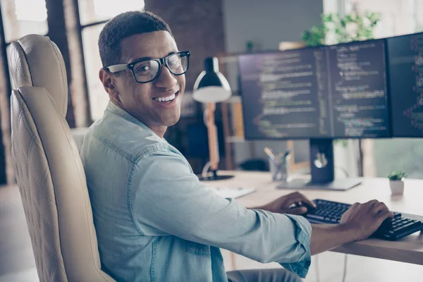 Photo of expert guy developer programmer looking at camera smiling when editing code creating new app in office workplace next to computer.