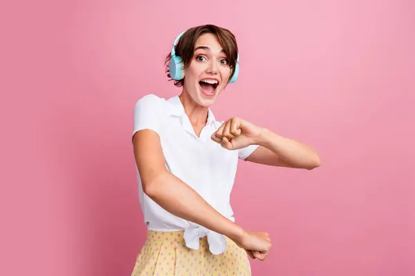 若い女性の写真は ピンク色の背景に隔離ブルーヘッドフォンでポップミュージックを踊るスカートブギーウーギーでスタイリッシュなシャツを着用します — ストック写真