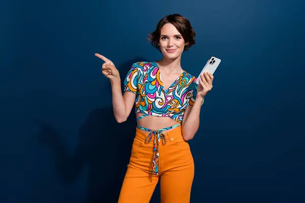 免提手指模型的年轻女孩的照片拿着现代智能手机在网上购买带有蓝色背景的老式服装 — 图库照片