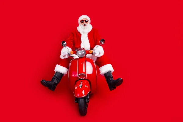 印象的なスピーチレスのカリスマ性サンタドライブスクーターの完全なボディ肖像画 空のスペース 赤い色の背景で隔離された新しい年の広告 — ストック写真