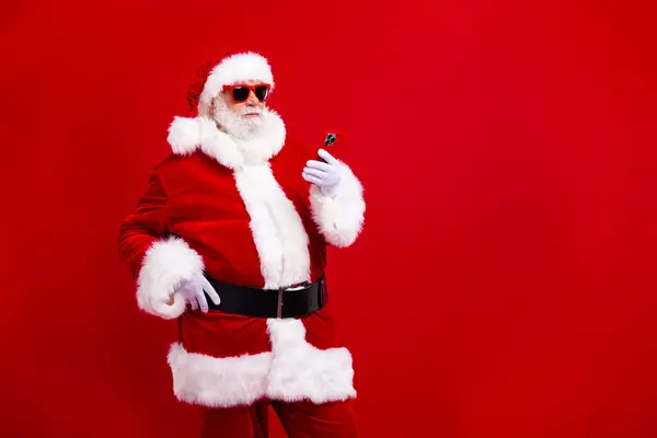 高齢者のサンタクロースの肖像画は 赤い色の背景で隔離されたスマートフォン空のスペースクリスマス情報を使用します — ストック写真
