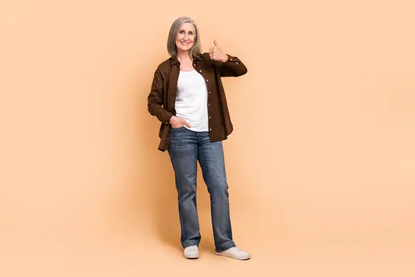 Full body length photo of retired businesswoman thumb up symbol rating good job intern new candidate isolated on beige color background.