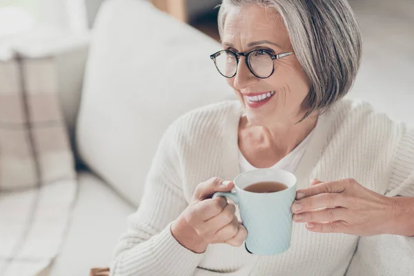 美しく愛らしい高齢女性の写真は 屋内アパートの部屋でテレビを見ている白いカーディガン飲料コーヒーを着用します — ストック写真