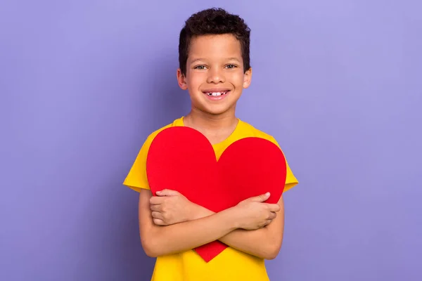 Фотография Оптимистичного Мальчика Носить Желтую Стильную Одежду Обнимая Красный Плакат — стоковое фото