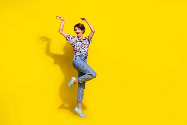 全长照片无忧无虑的疯狂女孩举起双臂跳舞冰冷的空旷空间广告隔离在黄色背景下 — 图库照片