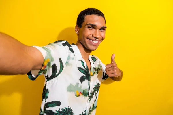 照片上可笑的 滑稽的 滑稽的 穿着棕榈纹衬衫的男人展示大拇指的样子 表示赞成在黄色背景下进行自我分离 — 图库照片