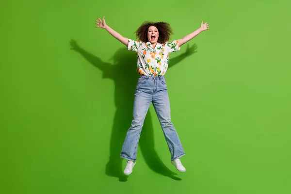 全长照片 漂亮兴奋的女士穿着印花衬衫跳得高高的 像星星一样孤零零的绿色背景 — 图库照片