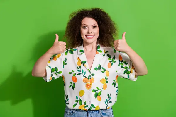Photo of excited funky lady wear print shirt showing two thumbs up isolated green color background.