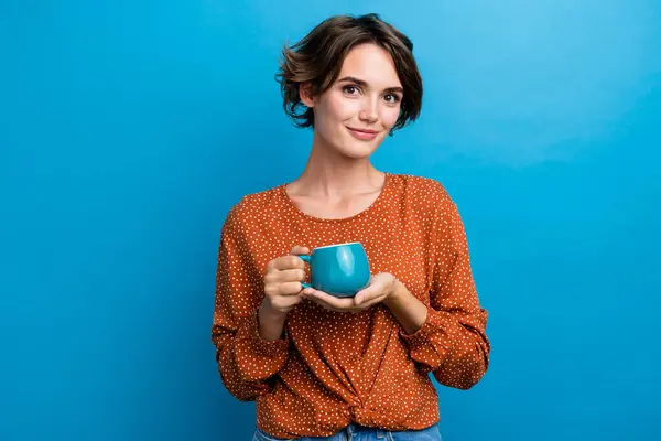 漂亮姑娘拿着茶杯的照片肖像 享受早晨穿着时髦的褐色衣服 蓝色背景与之隔离 — 图库照片