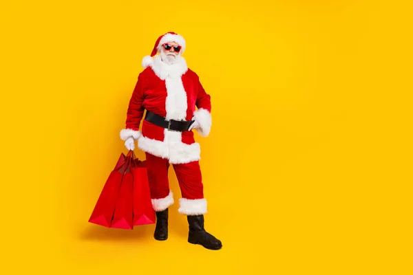 身着红色服装的圣诞老人拿着黄色背景的购物袋庆祝新年的全景照片 — 图库照片