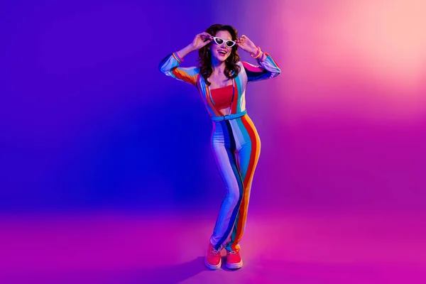 Photo of pretty excited lady wear striped overall arms hands dark glasses having fun isolated gradient pink purple color background.