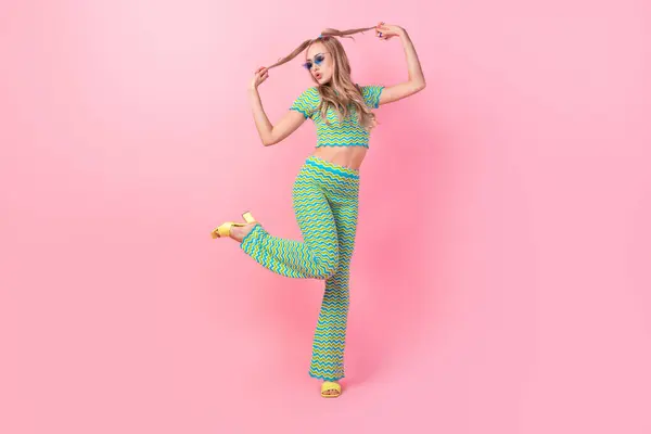 ピンク色の背景に隔離されたスタイリッシュな緑の印刷物の服を着た美しい若い女性の完全な長さの写真 — ストック写真
