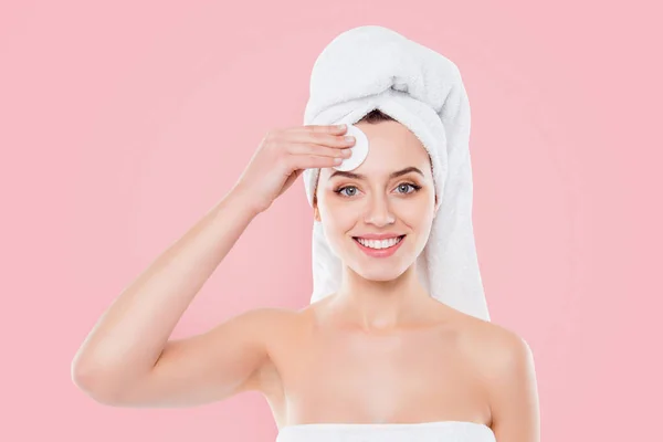 Portrait of attractive girl with towel on her head isolated on white background touching her forehead with sponge using tonic for problem skin looking at camera.