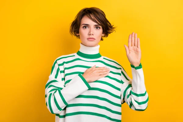 Photo of shiny serious lady wear striped pullover rising arm palm swearing tell truth isolated yellow color background.