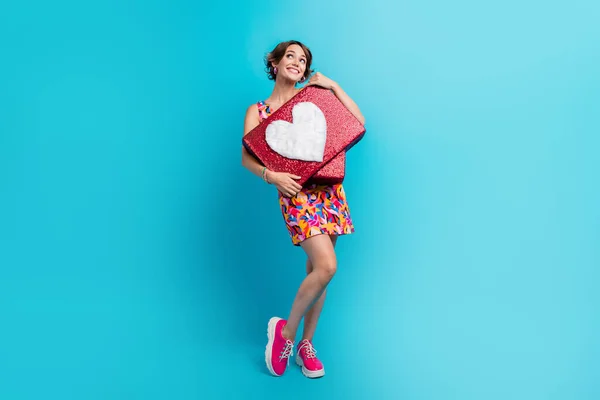 Full length photo of dreamy adorable lady wear print clothes hugging heart like sign looking empty space isolated blue color background.