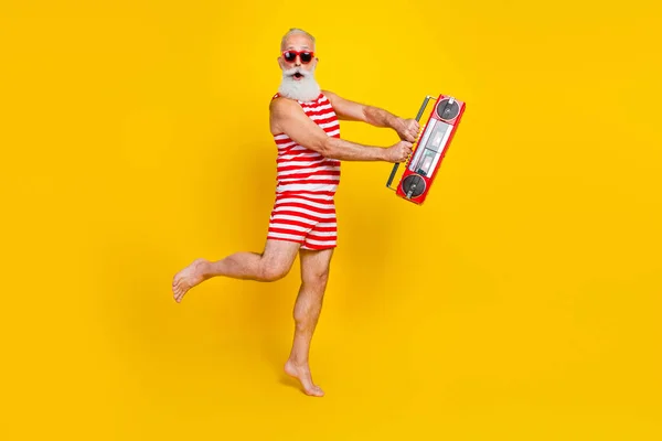 Full length photo of aged man gray bearded hurry up last chance buy tickets for summer ibiza nightclub isolated on yellow color background.