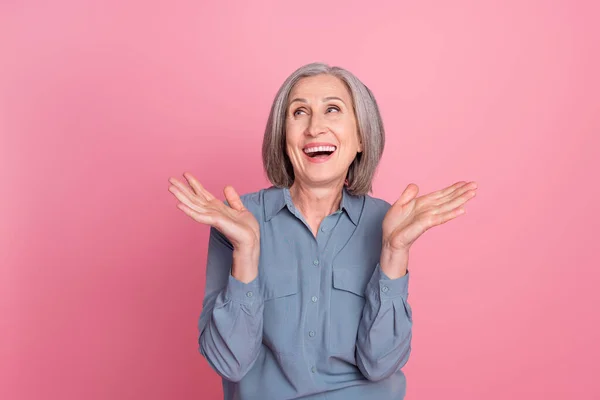 ファンキーな面白い面白い興奮した引退した女性の写真 青いスタイリッシュなシャツを着た ピンクの背景に隔離された空のスペースを笑う — ストック写真