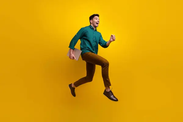 ポジティブな幸せな男性の写真は 黄色の背景に隔離されたブラックフライデーを急いで空のスペースを実行しているトレンディな服を着ます — ストック写真