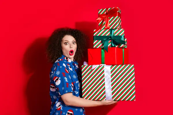 可爱的年轻女士的照片肖像 保存着令人惊讶的堆放礼品盒 礼品盒穿着时尚的蓝色印花圣诞服装 背景为红色 — 图库照片